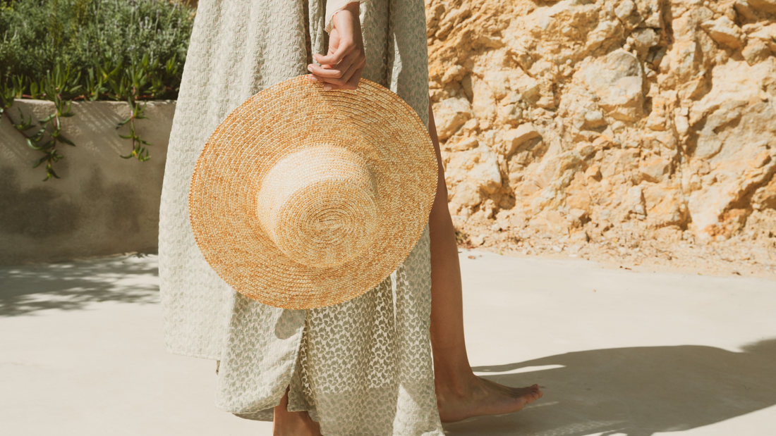 Woman with summer hat walking on the beach 